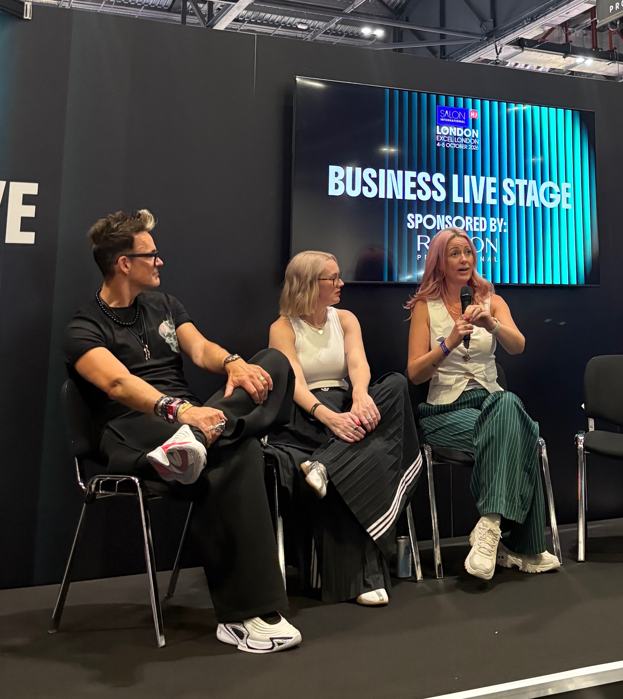 Chloe speaking on the stage at salon international with fellow panelists